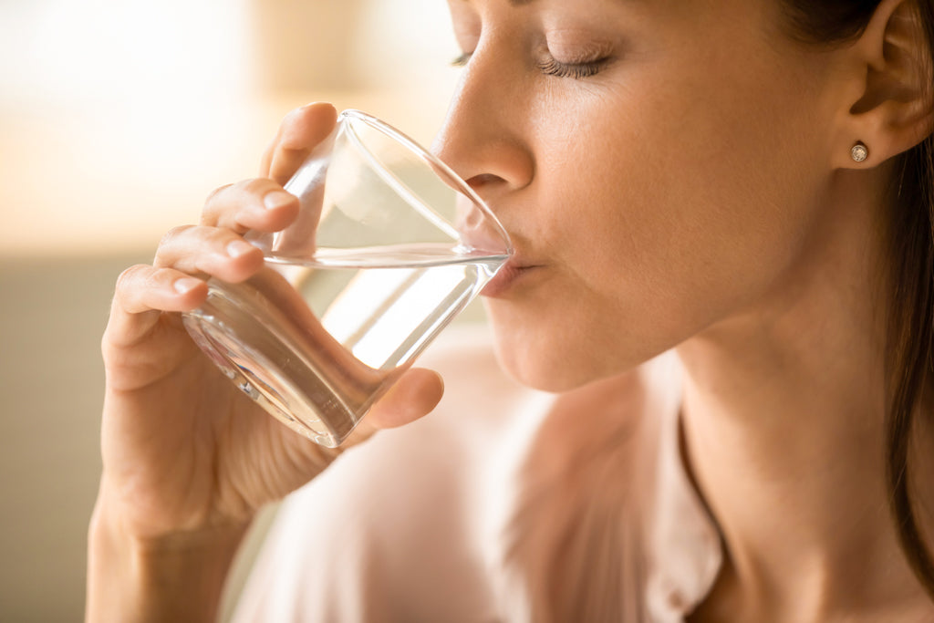 Frau trinkt ein Glas Wasser