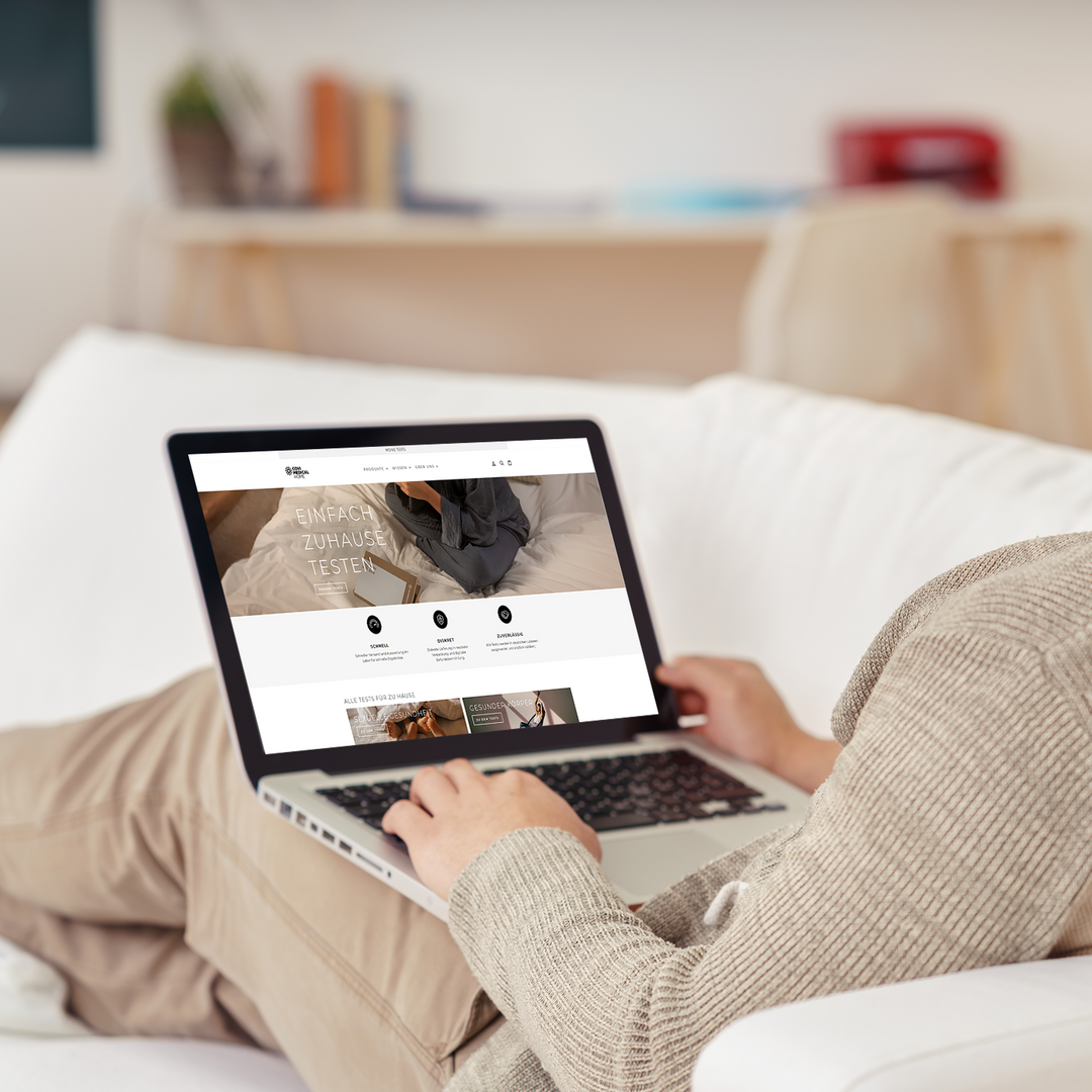 Mann von hinten liegend auf dem Sofa mit Laptop 